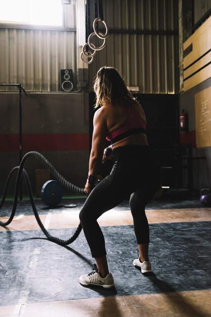 Mujer entrenando con cuerda en gimnasio