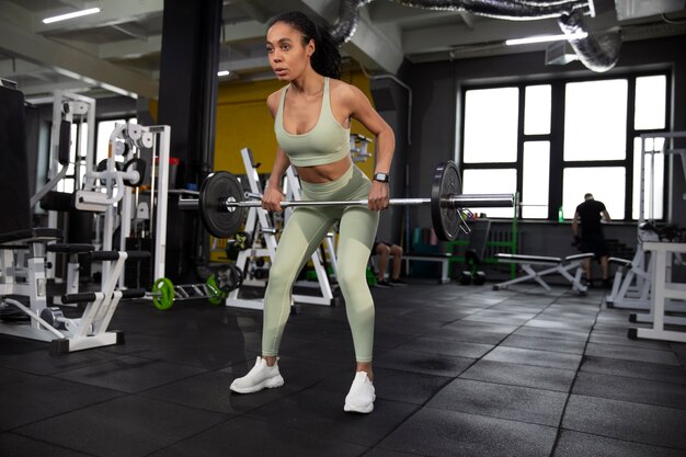 Mujer entrenando para levantamiento de pesas en el gimnasio