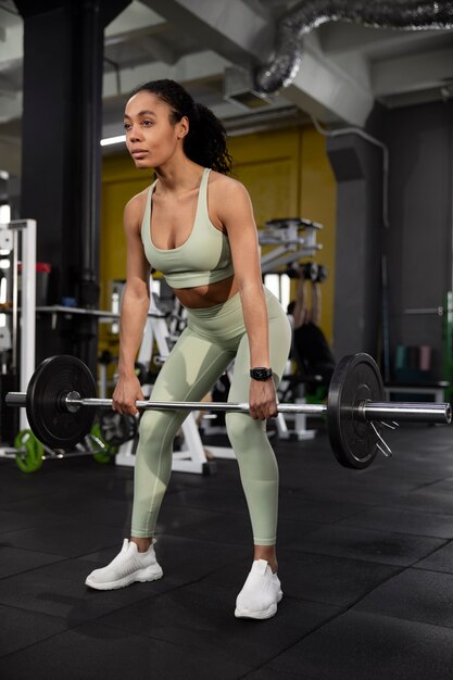 Mujer entrenando para levantamiento de pesas en el gimnasio