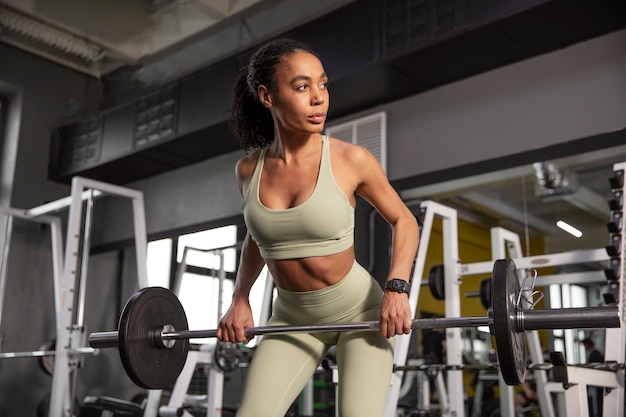 Mujer entrenando para levantamiento de pesas en el gimnasio