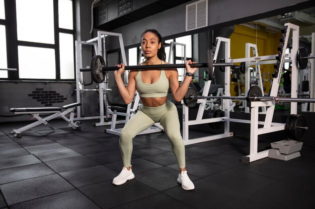 Mujer entrenando para levantamiento de pesas en el gimnasio