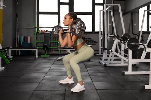 Mujer entrenando para levantamiento de pesas en el gimnasio