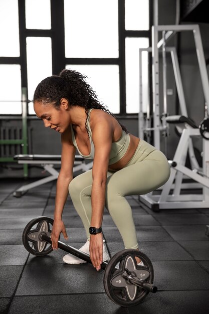 Mujer entrenando para levantamiento de pesas en el gimnasio