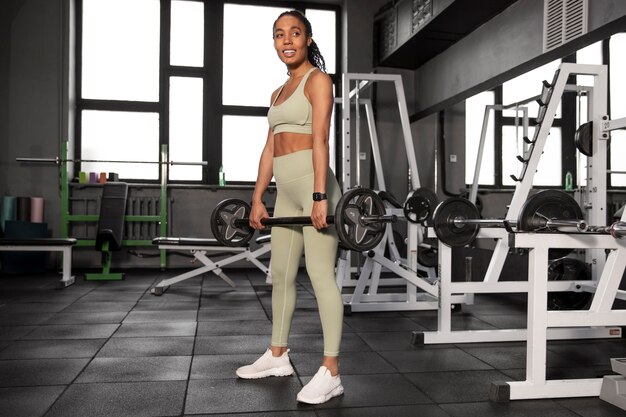 Mujer entrenando para levantamiento de pesas en el gimnasio