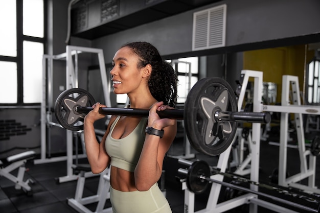 Foto gratuita mujer entrenando para levantamiento de pesas en el gimnasio