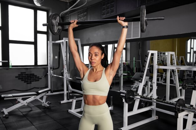 Mujer entrenando para levantamiento de pesas en el gimnasio