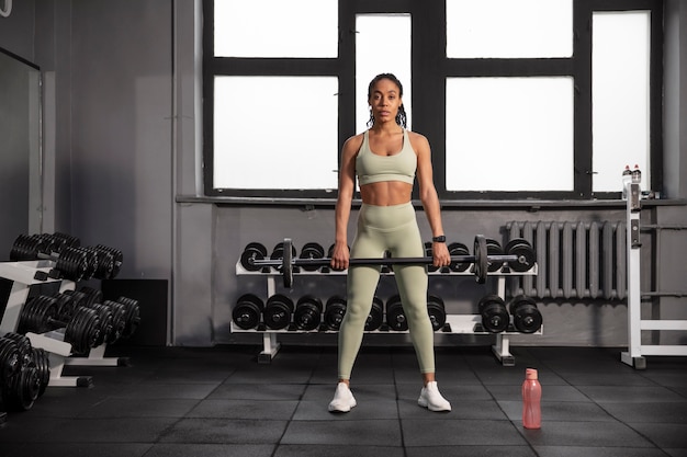 Mujer entrenando para levantamiento de pesas en el gimnasio