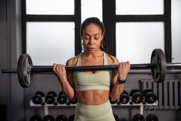 Mujer entrenando para levantamiento de pesas en el gimnasio