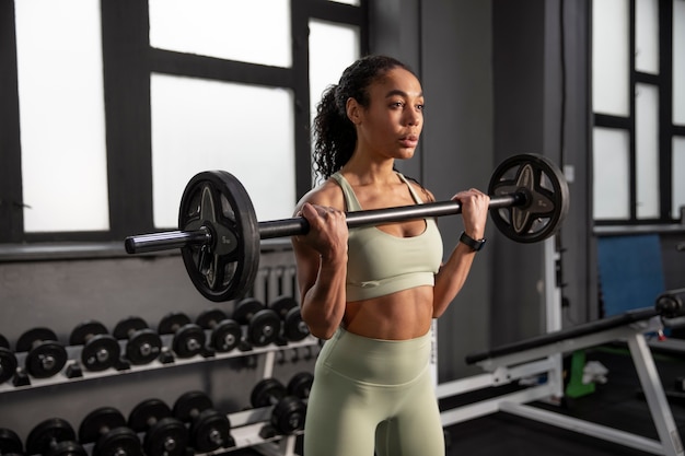 Mujer entrenando para levantamiento de pesas en el gimnasio