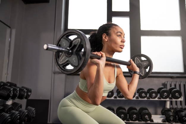 Mujer entrenando para levantamiento de pesas en el gimnasio