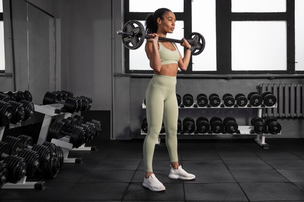 Mujer entrenando para levantamiento de pesas en el gimnasio