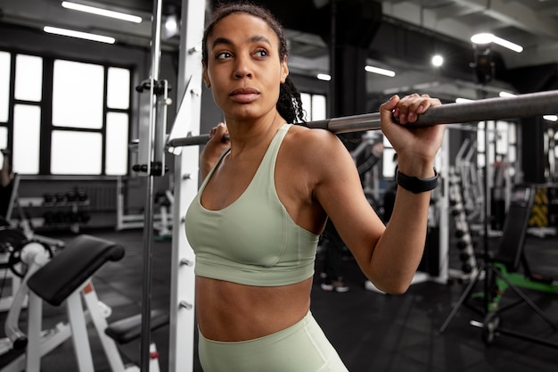 Mujer entrenando para levantamiento de pesas en el gimnasio