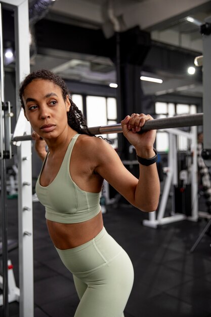 Mujer entrenando para levantamiento de pesas en el gimnasio