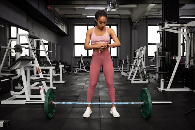 Foto gratuita mujer entrenando para levantamiento de pesas en el gimnasio