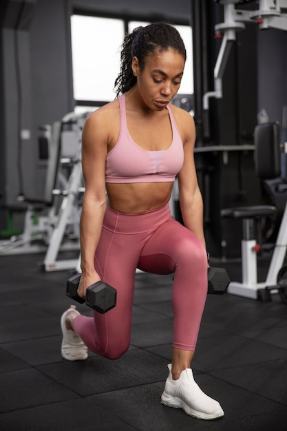 Foto gratuita mujer entrenando para levantamiento de pesas en el gimnasio