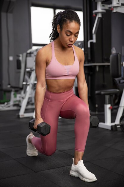 Mujer entrenando para levantamiento de pesas en el gimnasio