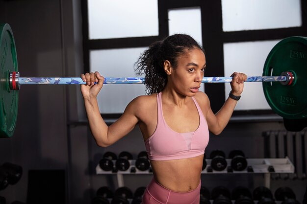 Mujer entrenando para levantamiento de pesas en el gimnasio