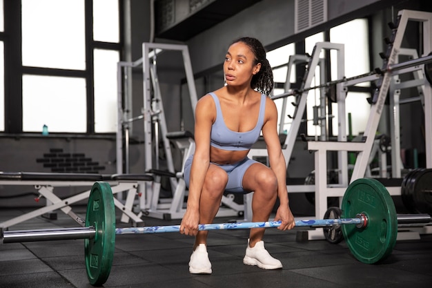 Mujer entrenando para levantamiento de pesas en el gimnasio