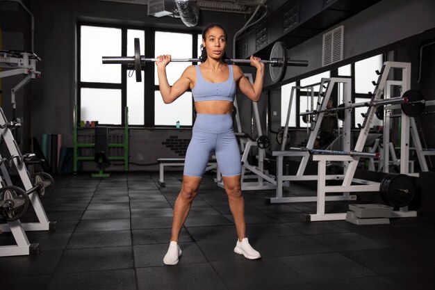 Mujer entrenando para levantamiento de pesas en el gimnasio