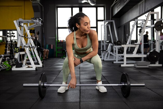 Mujer entrenando para levantamiento de pesas en el gimnasio