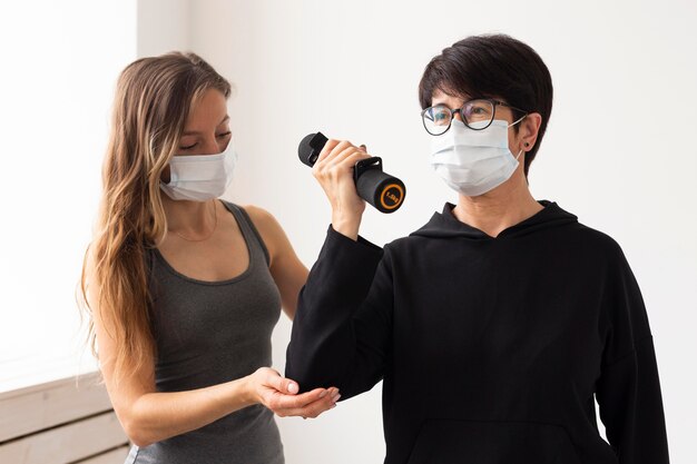 Mujer entrenando con pesas tras tratamiento por coronavirus