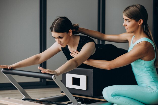 Mujer entrenando a pilates en el reformador