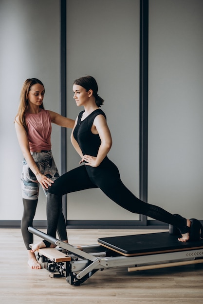 Foto gratuita mujer entrenando a pilates en el reformador