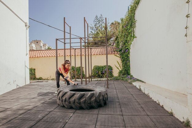 Mujer entrenando con rueda de tractor