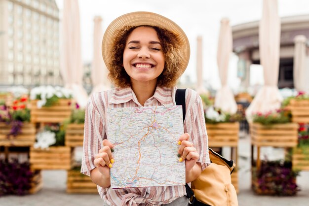 Mujer entusiasta que viaja sola sosteniendo un mapa