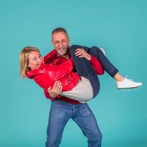 Mujer envejecida sonriente en las manos del hombre feliz