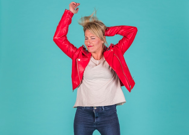 Mujer envejecida vestida de rojo con las manos levantadas.