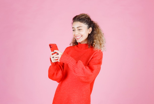 mujer enviando mensajes de texto en su nuevo teléfono inteligente y sintiéndose feliz.