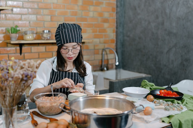 Mujer envuelta en albóndigas Cocinero de comida asiática.