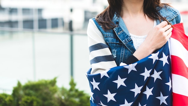 Mujer envuelta en gran bandera americana