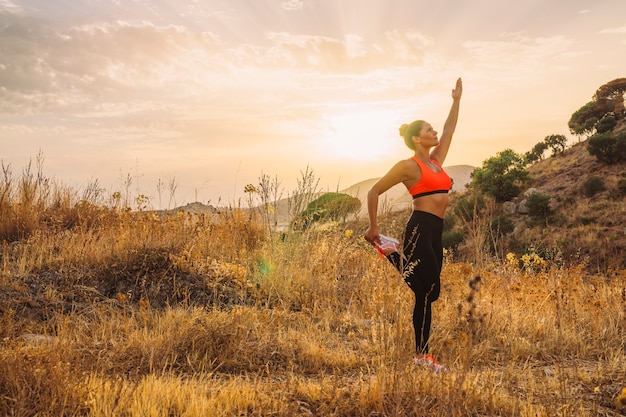 Mujer equilibrada estirando en la naturaleza