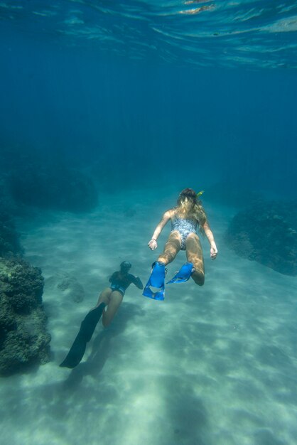 Mujer con equipo de buceo nadando en el océano