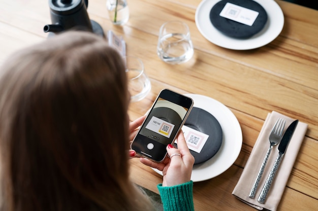 Mujer escaneando código qr con teléfono de alto ángulo