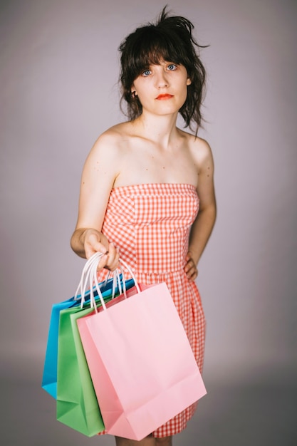 Foto gratuita mujer escéptica con bolsas de papel