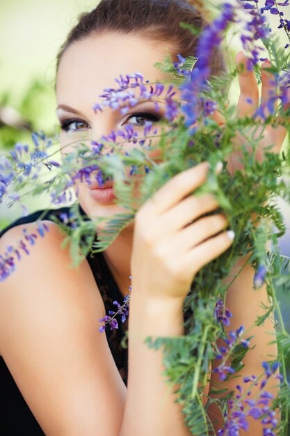 Mujer escondida detrás de flores lilas