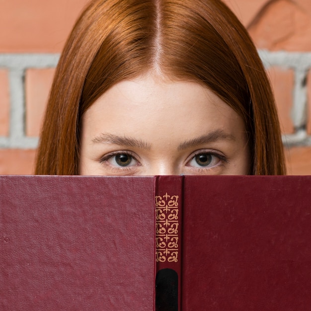 Mujer escondida detrás de un libro