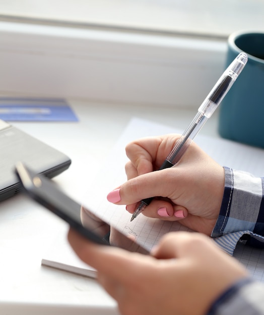 Mujer escribe en cuaderno