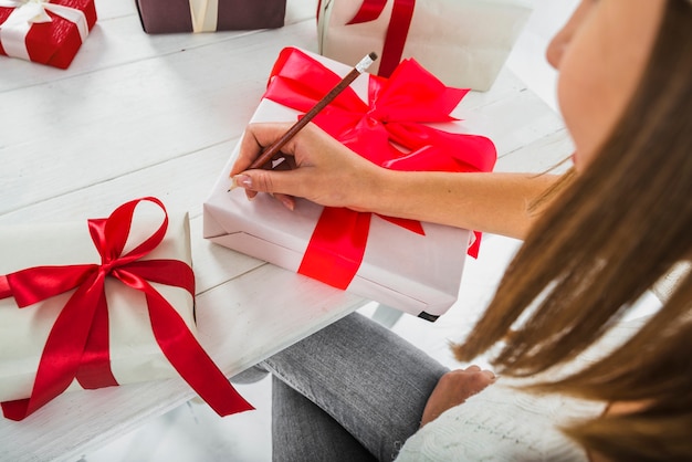 Mujer escribiendo en caja de regalo