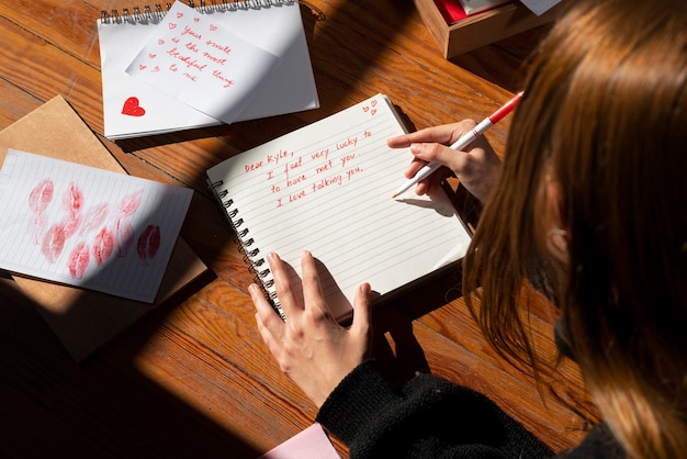 Foto gratuita una mujer escribiendo una carta de amor romántica a alguien