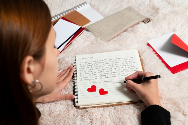 Foto gratuita una mujer escribiendo una carta de amor romántica a alguien