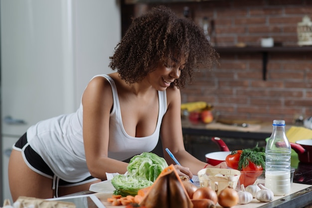 Mujer escribiendo en cocina