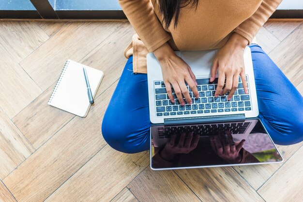 Mujer escribiendo en la computadora portátil