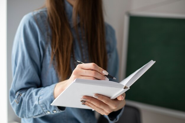 Mujer escribiendo en un cuaderno en el interior