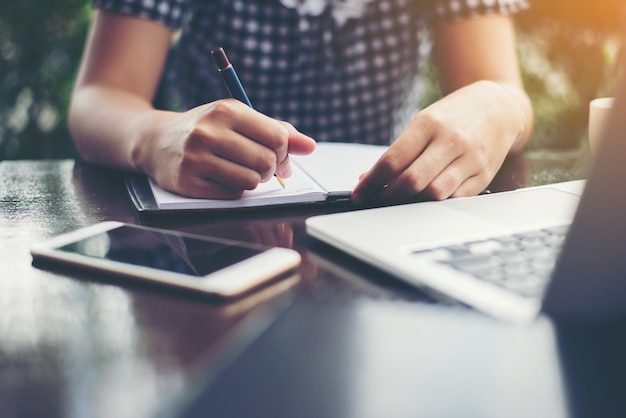 Foto gratuita mujer escribiendo en un cuaderno