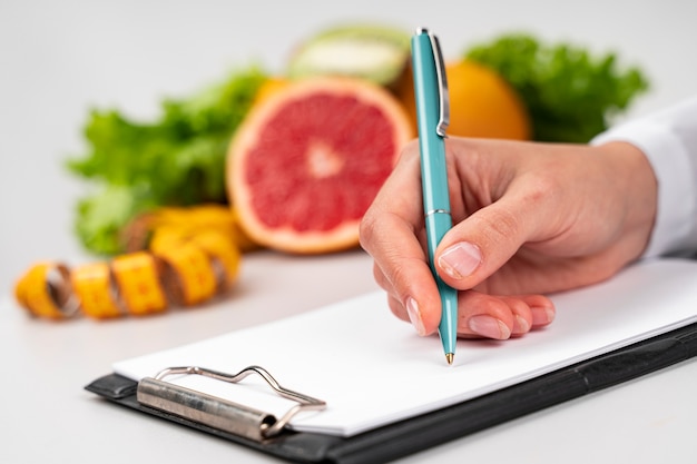 Mujer escribiendo y fruta borrosa