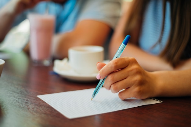 Mujer escribiendo en una hoja de papel